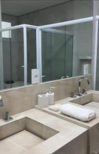 La salle de bains est pourvue de 2 lavabos et d'un grand miroir. dans l'établissement Locação Terras de São Francisco, Quarto Privativo Palmeira Imperial, à Andradas
