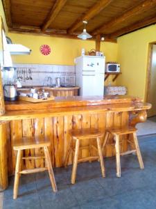 eine Küche mit einer Holztheke und 2 Hockern in der Unterkunft Cabañas franlu in Lago Puelo
