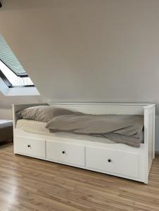 ein weißes Bett in einem Schlafzimmer mit einer Decke in der Unterkunft Einzel-Apartment Düsseldorf Oberkassel in Düsseldorf
