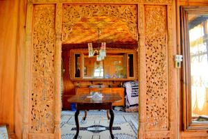una sala da pranzo con tavolo e specchio di Kings Houseboats a Srinagar