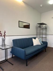 波茲南的住宿－Expo Apartments，客厅配有一张蓝色的沙发,配有一张桌子