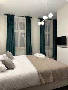 um quarto com uma cama grande e cortinas verdes em Expo Apartments em Poznań