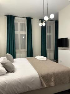 a bedroom with a large bed with green curtains at Expo Apartments in Poznań