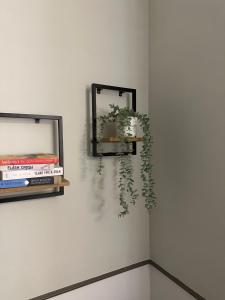 a mirror on a wall with a plant on a shelf at Expo Apartments in Poznań