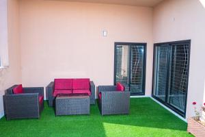 a patio with chairs and a table and grass at COMFORT HOME in Gujrāt