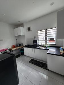 Η κουζίνα ή μικρή κουζίνα στο Thetamu Homestay مسلم Kepala Batas +11 φωτογραφίες