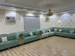 a large waiting room with green couches and a screen at شالية سحاب in Medina