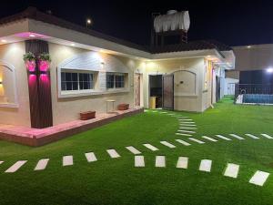 ein Haus mit grünem Rasen davor in der Unterkunft شالية سحاب in Medina