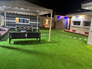a backyard with green grass and a tent at شالية سحاب in Al Madinah