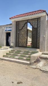 a building with a gate and stairs in front of it at شالية سحاب in Al Madinah