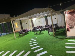 Pokój z namiotem, stołem i krzesłami w obiekcie شالية سحاب w Medynie