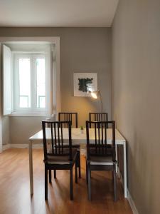 uma sala de jantar com 2 cadeiras, uma mesa e uma janela em River View Center em Lisboa