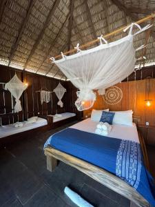 a bedroom with a bed with a mosquito net at Atins Beach Chalés in Atins