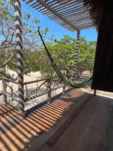 a porch with a hammock on a beach at Atins Beach Chalés in Atins