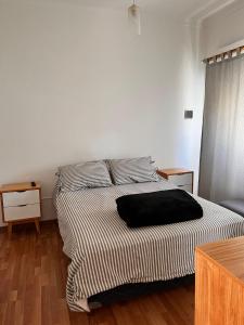 um quarto com uma cama com uma almofada preta em CASA EN LA FELIZ - pet friendly em Mar del Plata