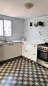 uma cozinha com azulejos brancos no chão em CASA EN LA FELIZ - pet friendly em Mar del Plata