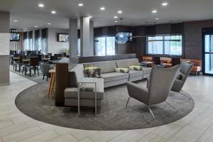 hol z kanapą, krzesłami i barem w obiekcie SpringHill Suites by Marriott Chicago Bolingbrook w mieście Bolingbrook