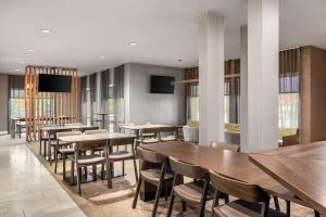 una sala da pranzo con tavoli e sedie in legno di SpringHill Suites by Marriott Chicago Bolingbrook a Bolingbrook