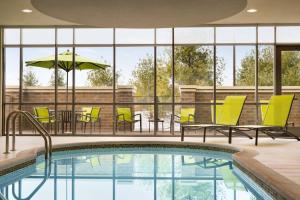 una piscina con sillas, una mesa y una sombrilla en SpringHill Suites by Marriott Allentown Bethlehem/Center Valley, en Center Valley