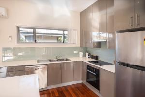 una cocina con electrodomésticos de acero inoxidable y una ventana en Ocean Stays - Mollymook, en Mollymook