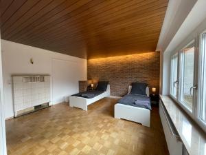 a bedroom with two beds and a brick wall at Worker Apartments near Ulm bis zu 11 Betten in Dornstadt