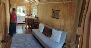 a living room with a couch in a tiny house at Cabaña Cordillera in Cochamó