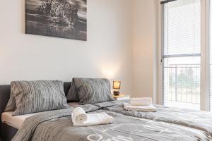 a bedroom with a bed with towels on it at Sunny Haven: Modern 2BR,Garage, WiFi,Stream in Bratislava +41 photos