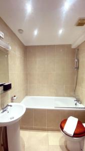 ein Badezimmer mit einer Badewanne und einem Waschbecken in der Unterkunft UK CHAPS Retreat: 2 Bedroom - 2Bathroom Apartment in London