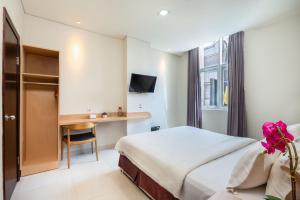 a hotel room with a bed and a desk at Life Hotel Soekarno Hatta Makassar in Makassar