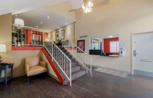 a lobby with a staircase with a chair and a ceiling fan at Extended Stay America Suites - Dayton - South in Dayton
