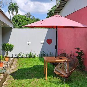una mesa y sillas con una sombrilla en un patio en Casa vista de luna, en Guaria