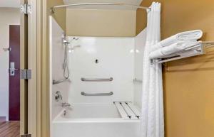 a shower in a bathroom with a white shower curtain at Studio 6 - St Louis, MO - Westport-Craig Road in Maryland Heights +36 photos