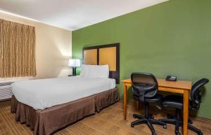 a room with a bed and a desk and a bed and a chair at Extended Stay America Suites - Evansville - East in Evansville