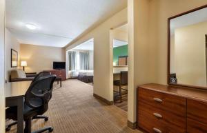 a hotel room with a desk and a bedroom at Extended Stay America Select Suites - Cincinnati - Florence - Meijer Dr in Florence