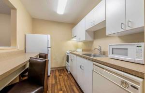 a kitchen with white cabinets and a sink and a microwave at Extended Stay America Suites - Evansville - East in Evansville