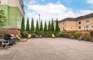 eine Terrasse mit Stühlen, einem Zaun und Bäumen in der Unterkunft Extended Stay America Suites - Evansville - East in Evansville