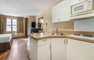 a kitchen with white cabinets and a sink in a room at Extended Stay America Suites - Minneapolis - Maple Grove in Maple Grove