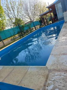 a swimming pool with blue water in front of a house at Casa de Funes city in Funes