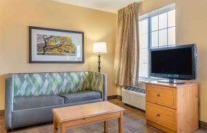 sala de estar con sofá y TV de pantalla plana en Extended Stay America Suites - Auburn Hills - University Drive, en Auburn Hills