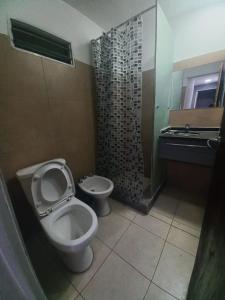 y baño con aseo y lavamanos. en Casa de Funes city en Funes