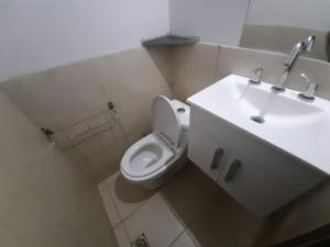 a bathroom with a white toilet and a sink at Casa de Funes city in Funes