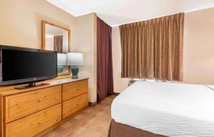 ein Hotelzimmer mit einem Bett und einem Flachbild-TV in der Unterkunft Extended Stay America Suites - Dallas - DFW Airport N in Irving