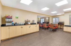 a waiting room with a restaurant with tables and chairs at Extended Stay America Suites - Orlando - Lake Buena Vista in Orlando
