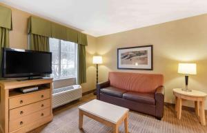 a living room with a couch and a television at Extended Stay America Suites - Orlando - Lake Buena Vista in Orlando