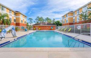 basen z krzesłami i budynek w obiekcie Extended Stay America Suites - Orlando - Lake Buena Vista w Orlando