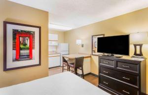 a hotel room with a bed and a desk with a television at Extended Stay America Suites - Salt Lake City - Sugar House in Salt Lake City