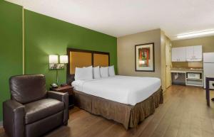 Pokój hotelowy z łóżkiem i krzesłem w obiekcie Extended Stay America Suites - Fresno - North w mieście Fresno