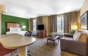 a hotel room with a bed and a couch and a table at Extended Stay America Suites - Atlanta - Gwinnett Place in Duluth