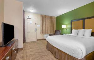 a hotel room with a bed and a flat screen tv at Extended Stay America Suites - Fort Lauderdale - Tamarac in Fort Lauderdale