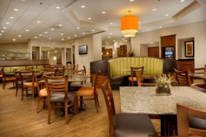 a restaurant with tables and chairs and a bar at Drury Inn & Suites Valdosta in Valdosta